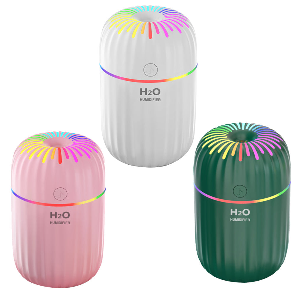Three colorful humidifiers in white, pink, and green on a white background