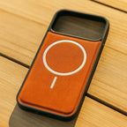 Phone case with a brown leather patch and white circular design on a wooden surface