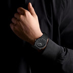 Person wearing a black smartwatch on a dark background