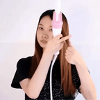 Person holding a pink hair straightener against a white background