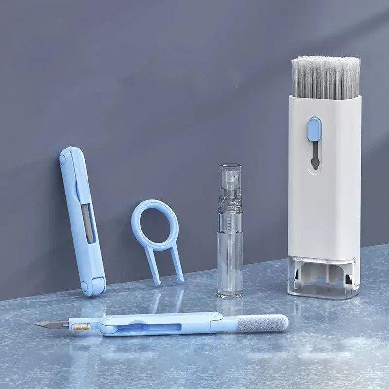 Set of cleaning tools including a brush, spray bottle, and other cleaning instruments on a reflective surface with a dark background.