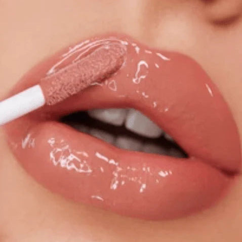 Close-up of a person applying lip gloss with a brush